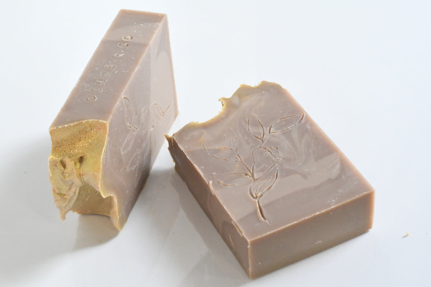 Two laying soap bars with a textured soft brown and beige swirls on a white background