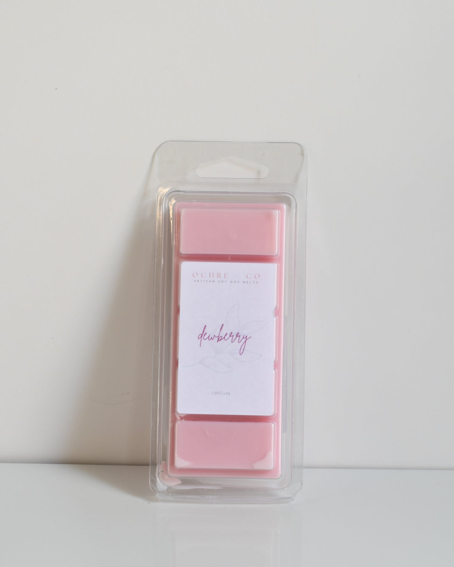 A pink wax melt bar in packaging, with the scent described as 'Dewberry' on the label.