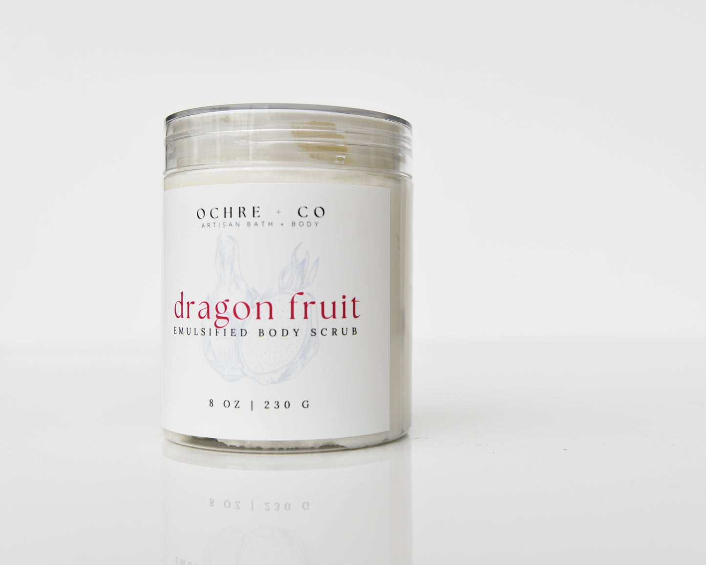 A jar of Dragon Fruit Sugar Scrub with a white label, placed on a white surface, with the brand 'OCHRE + CO' and product name clearly visible.