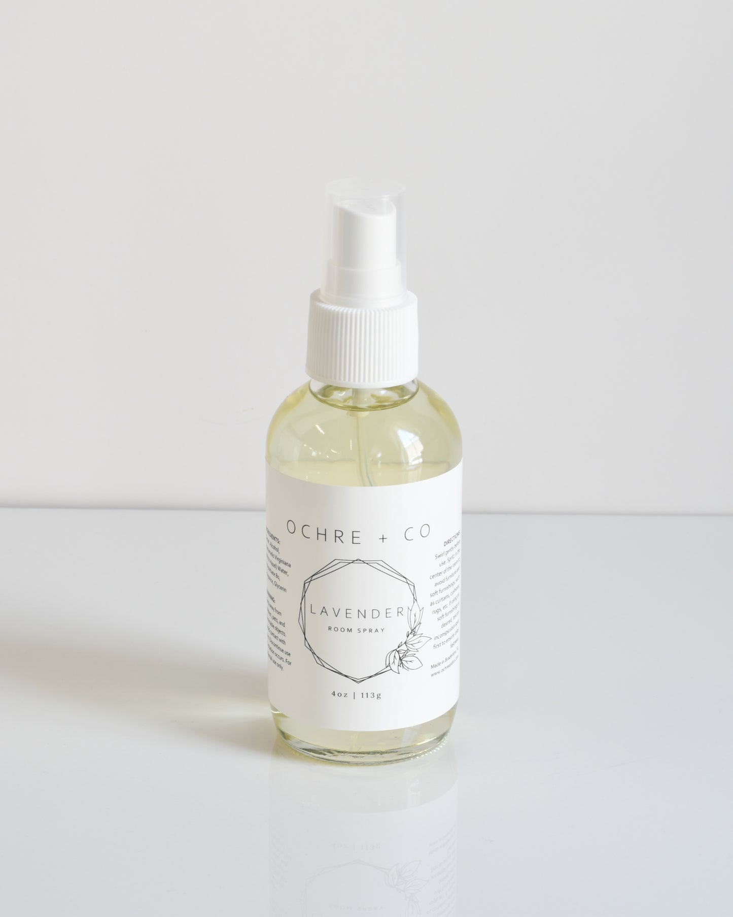 A clear bottle with a white spray nozzle labeled 'Lavender' filled with a light yellow liquid, on a white background.