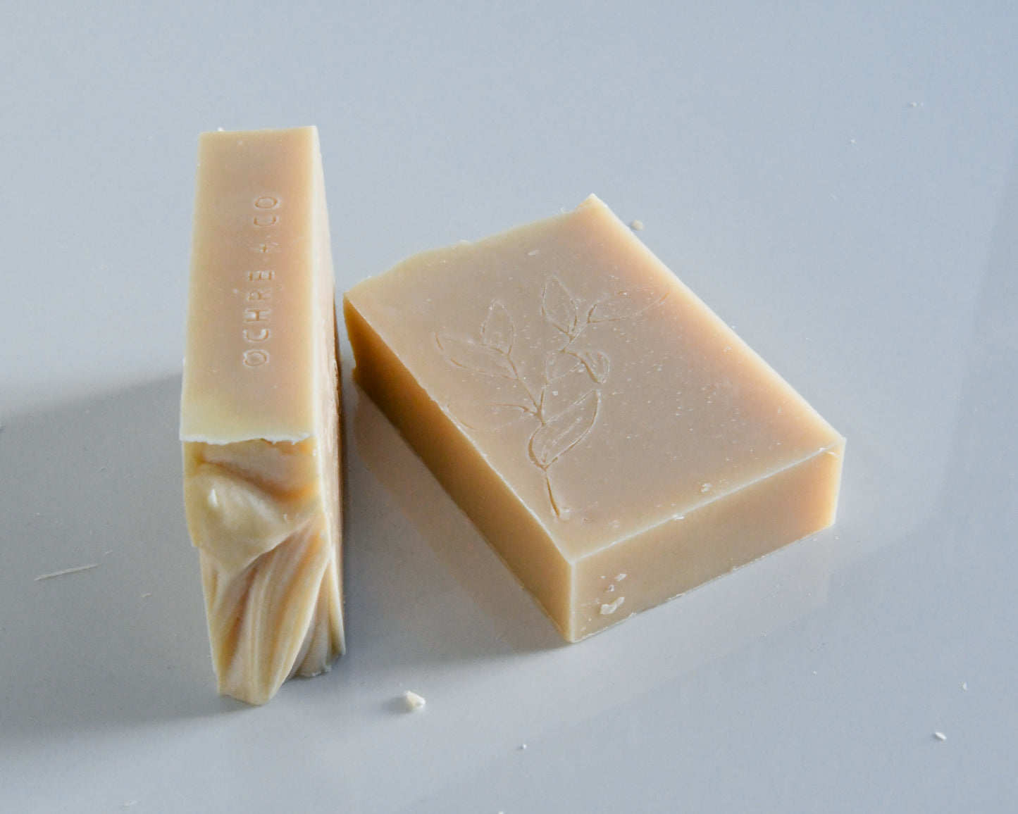 Two creamy white bars of soap on a white background