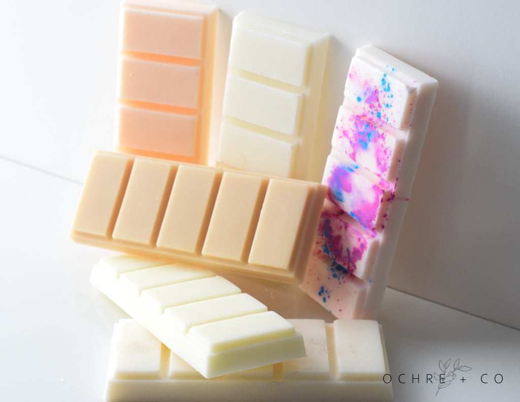 A grouping of various wax melts in different colors on a white background