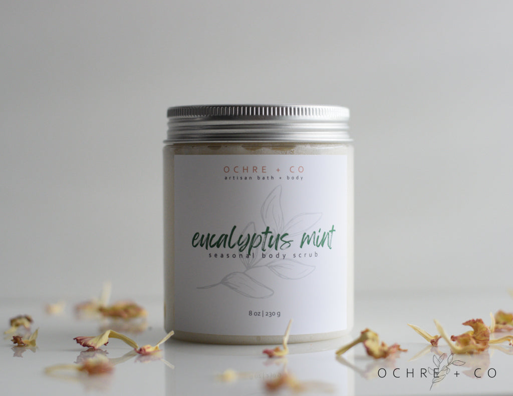 Eucalyptus Mint sugar scrub in a jar with a white background and scattered dried florals