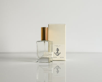 Perfume bottle and packaging on a reflective surface with a light background
