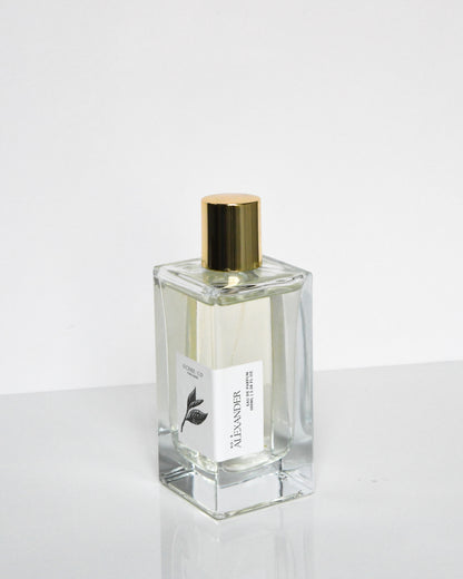 A clear glass bottle of 'Alexander - Eau de Parfum' with a gold-colored cap, positioned against a white background.