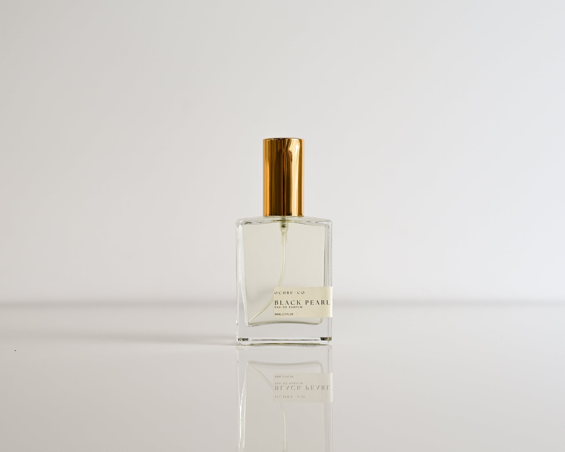Perfume bottle of Black Pearl on a white reflective surface and white background