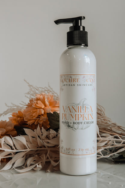 A bottle of white Vanilla Pumpkin pumpable body lotion on a white background with fall-colored dried florals