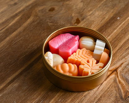 Golden Hour gold tin of varietal fall wax melt scents on a wood background