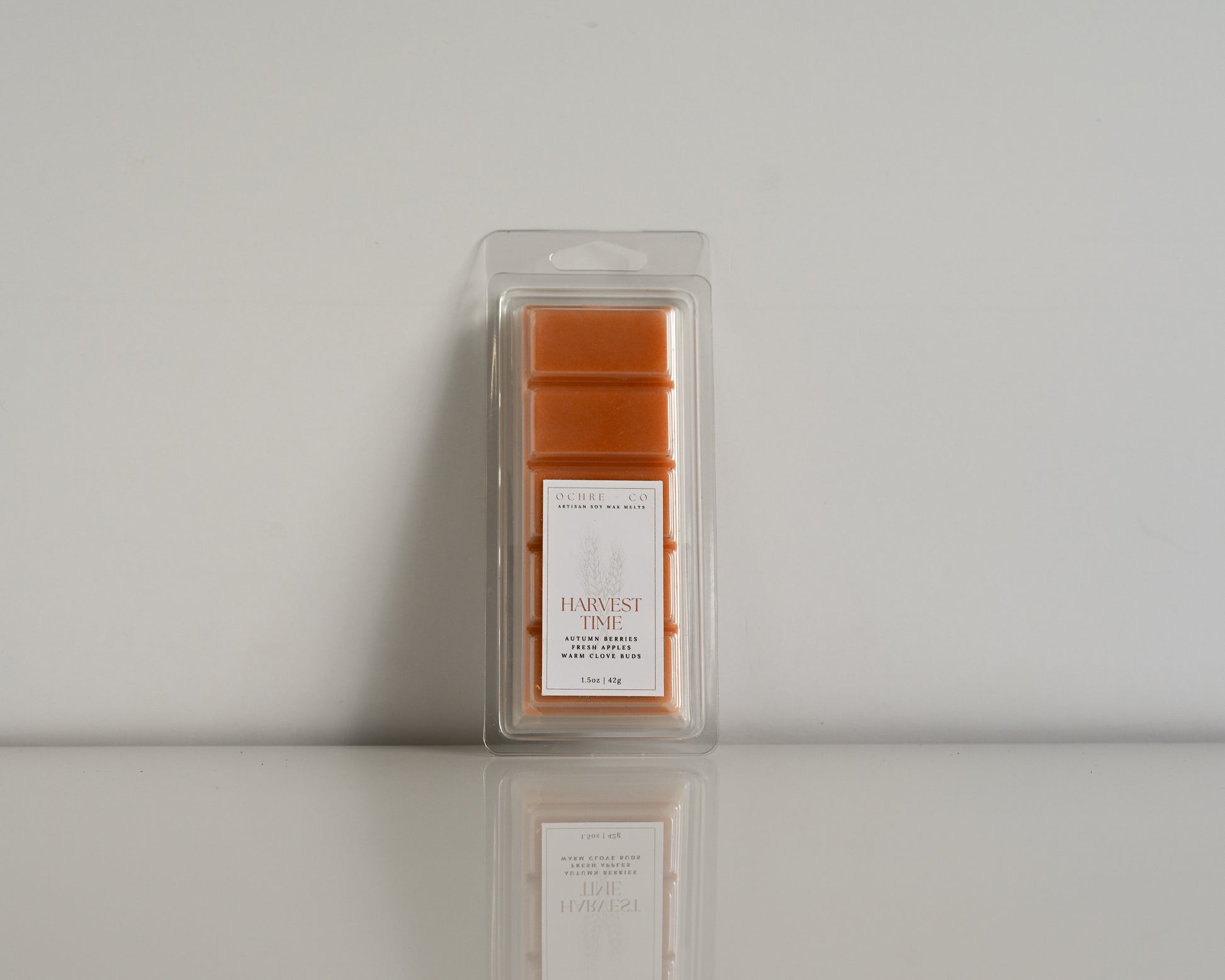 A single wax melt in a clear packaging with a label reading 'Harvest Time' on a white background