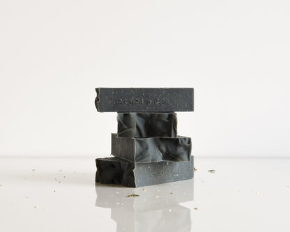 Stack of black soap bars with 'OCHRE + CO' branding on a white background
