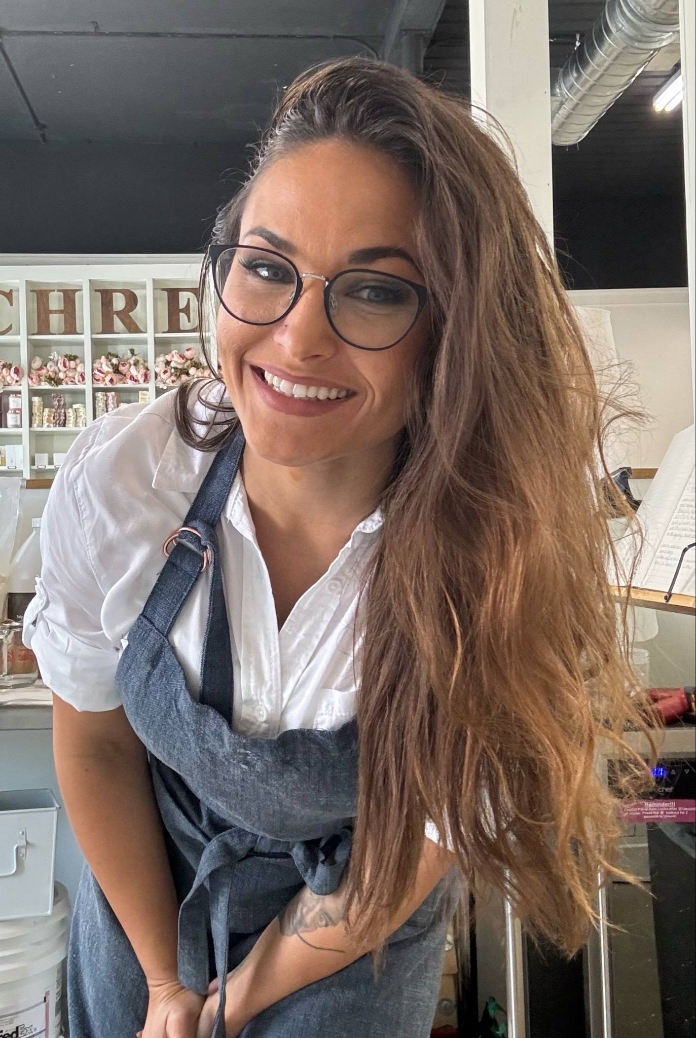 A woman wearing glasses and an apron working at the store
