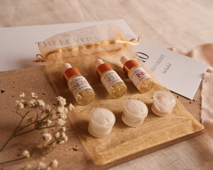 Cosmetic products including bottles and jars on a travertine tile with a beige background.