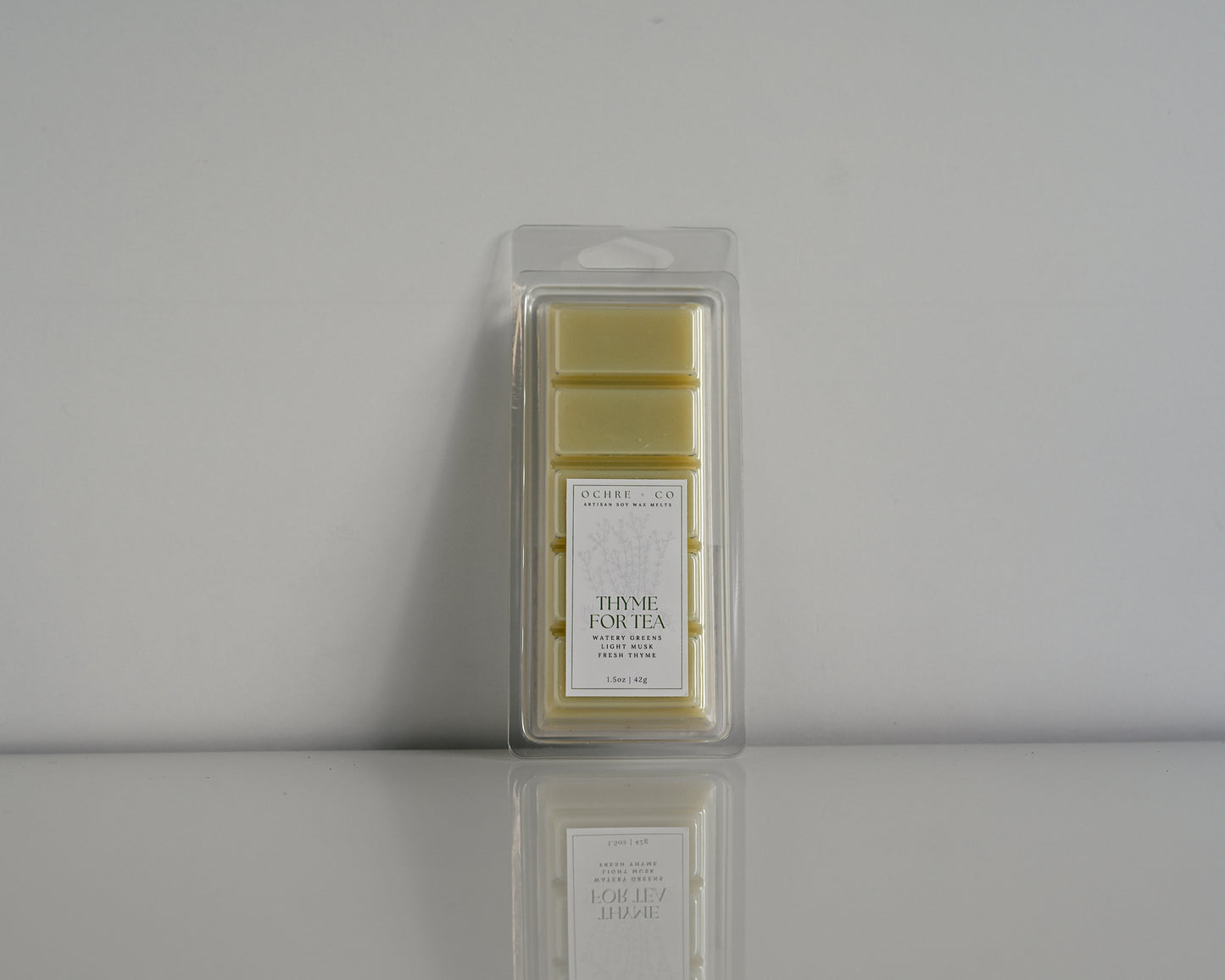 Thyme for Tea wax melt on a white background and reflective surface