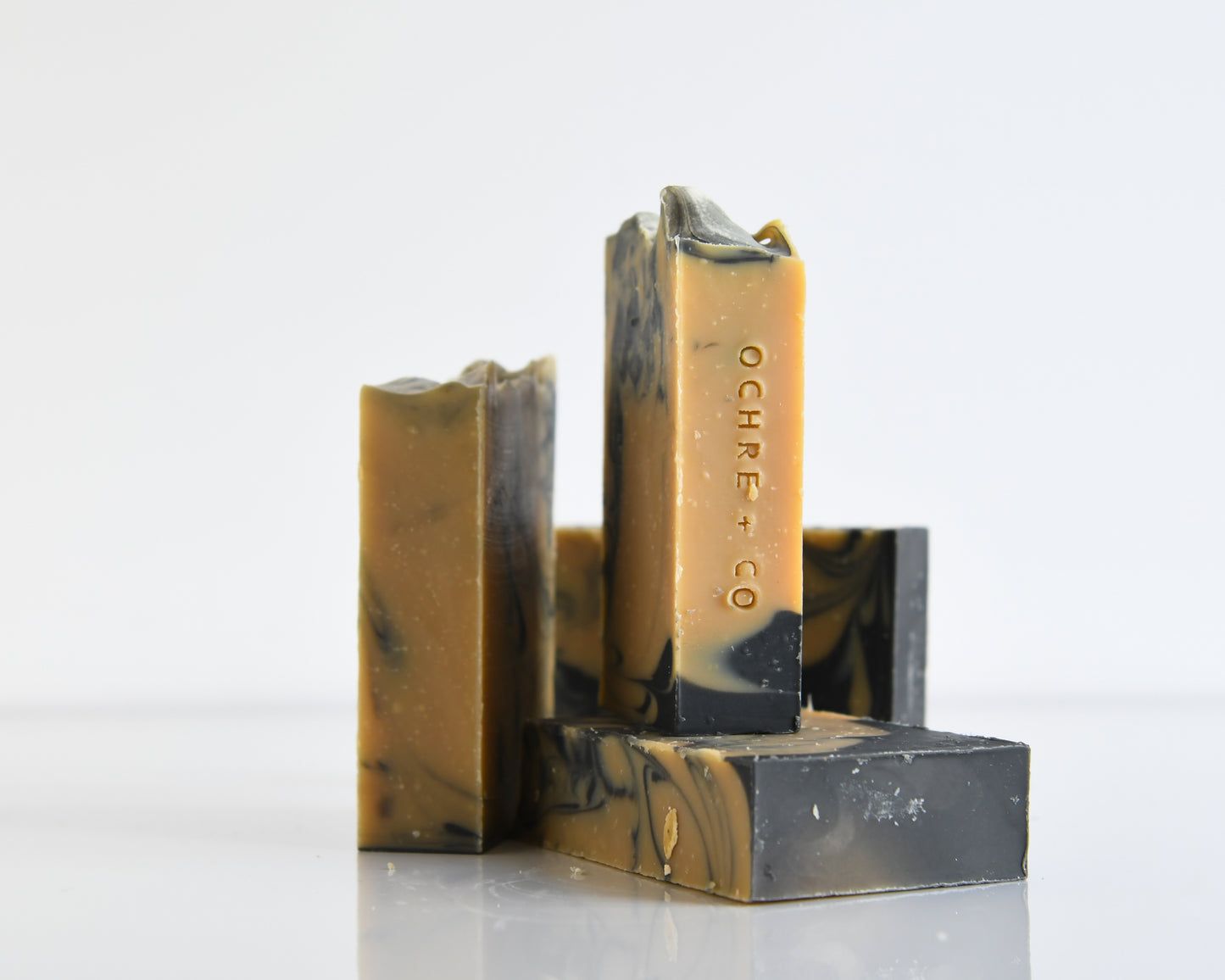 Four bars of marbled soap with 'Ochre + Co' branding on a white background