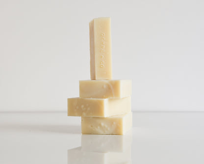 Three stacked soap bars with one standing on top on a white background