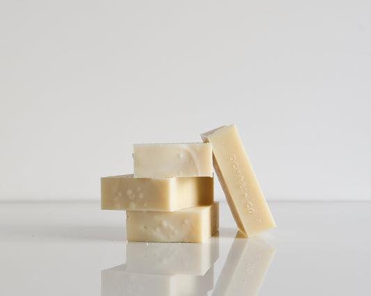 Stack of white soap bars on a white surface with a light white background