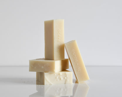 Stack of soap bars with 'Ochre & Co' branding on a reflective surface.