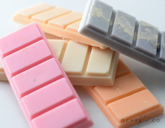 Colorful wax melts in pink, orange, and gray on a white background with 'Ochre & Co' branding.
